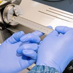 Nextern technician using a ruler to measure the dimensions of a medical device